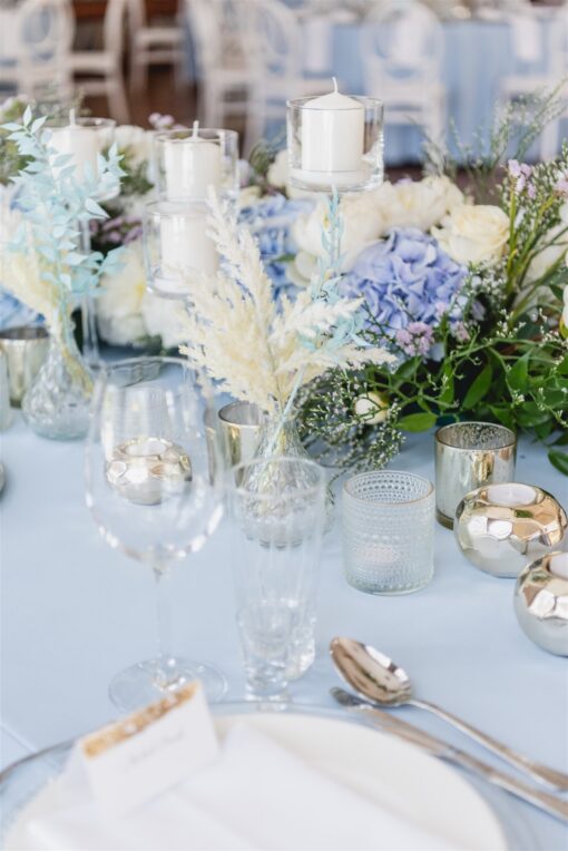 Dekoracja stołu weselnego, kryształowe świeczniki i biało niebieskie kwiaty