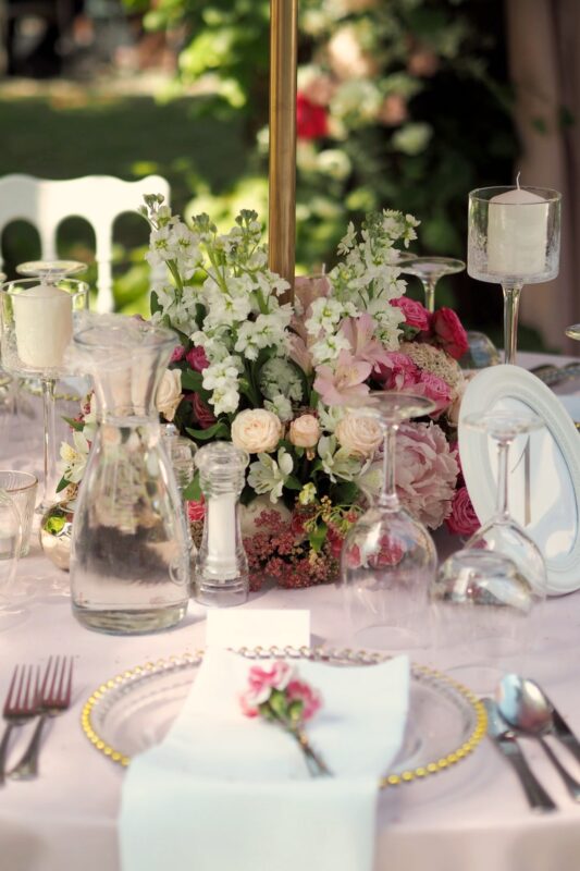 Elegancka dekoracja stołu w różowej kolorystyce z kompozycjami kwiatowymi.