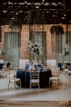 czarne obrusy na wesele z kompozycja na geometrycznych stojakach