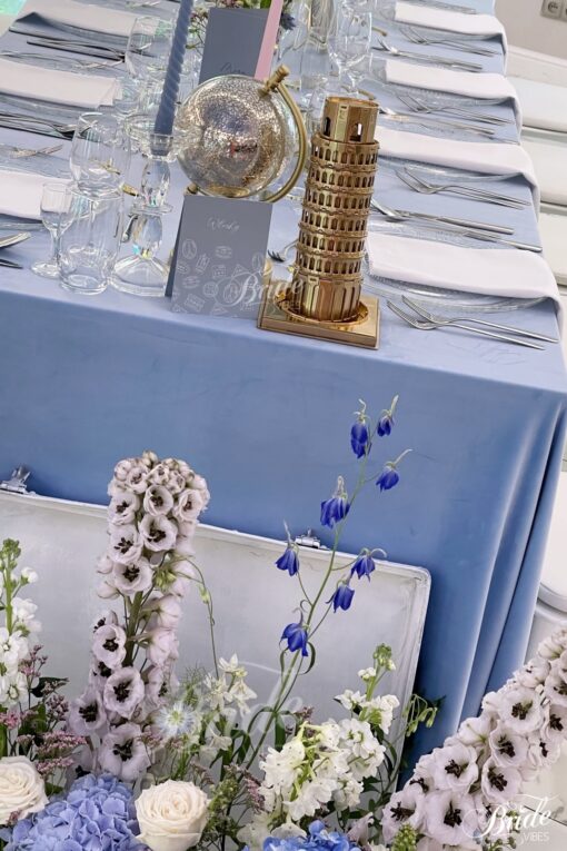 Niebieskie welurowe obrusy na sali ze złota dekoracją